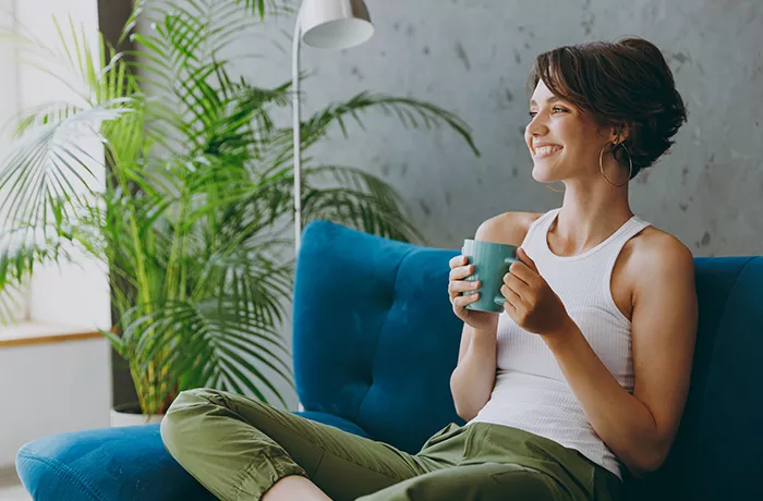 Woman relaxing on her sofa with a drink