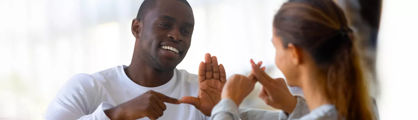 D/deaf man and woman communicating via sign language